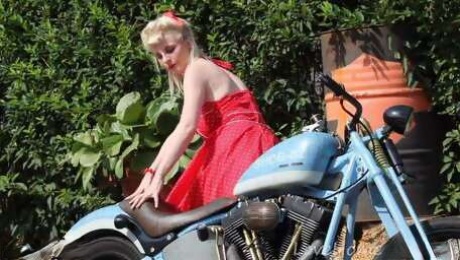 Cute blonde enjoys posing next to a bike